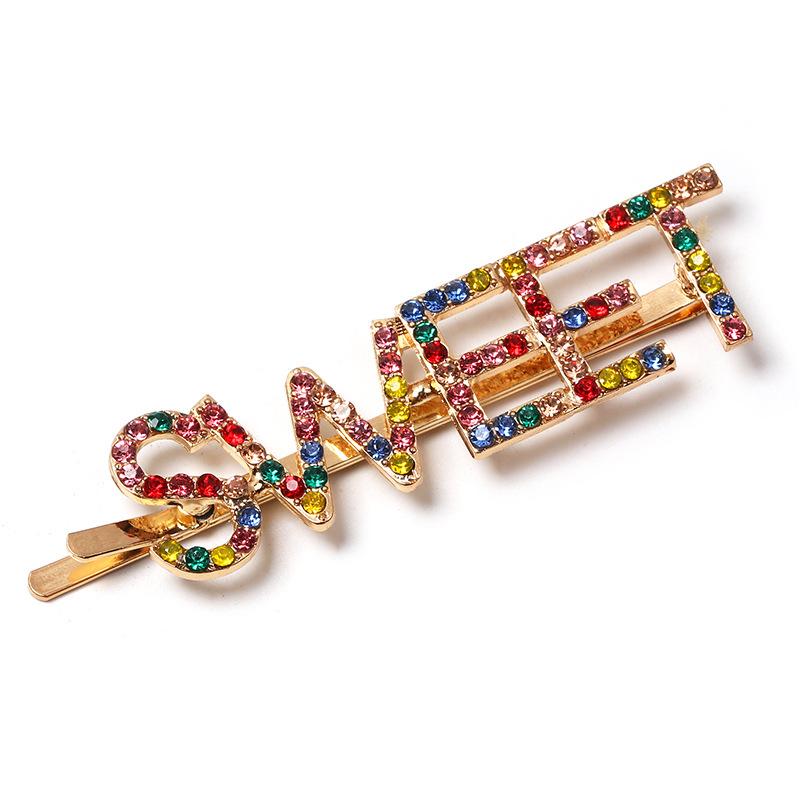 Gold colored hairpin with the word SWEET in colored faux diamond lettering.