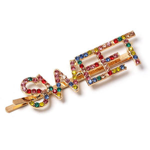 Open image in slideshow, Gold colored hairpin with the word SWEET in colored faux diamond lettering.
